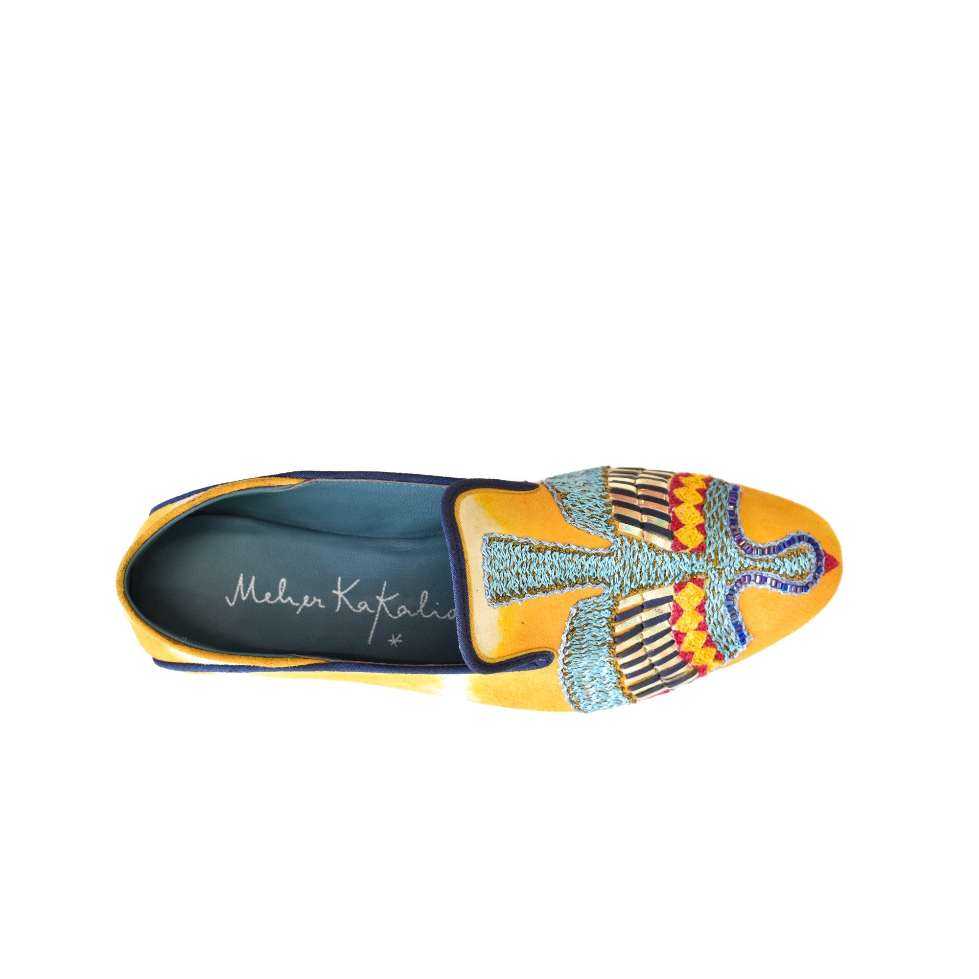 Top view of Meher Kakalia ANZU Moccasin in saffron yellow tie-dye suede with blue hand embroidery and Mukesh metallic detail