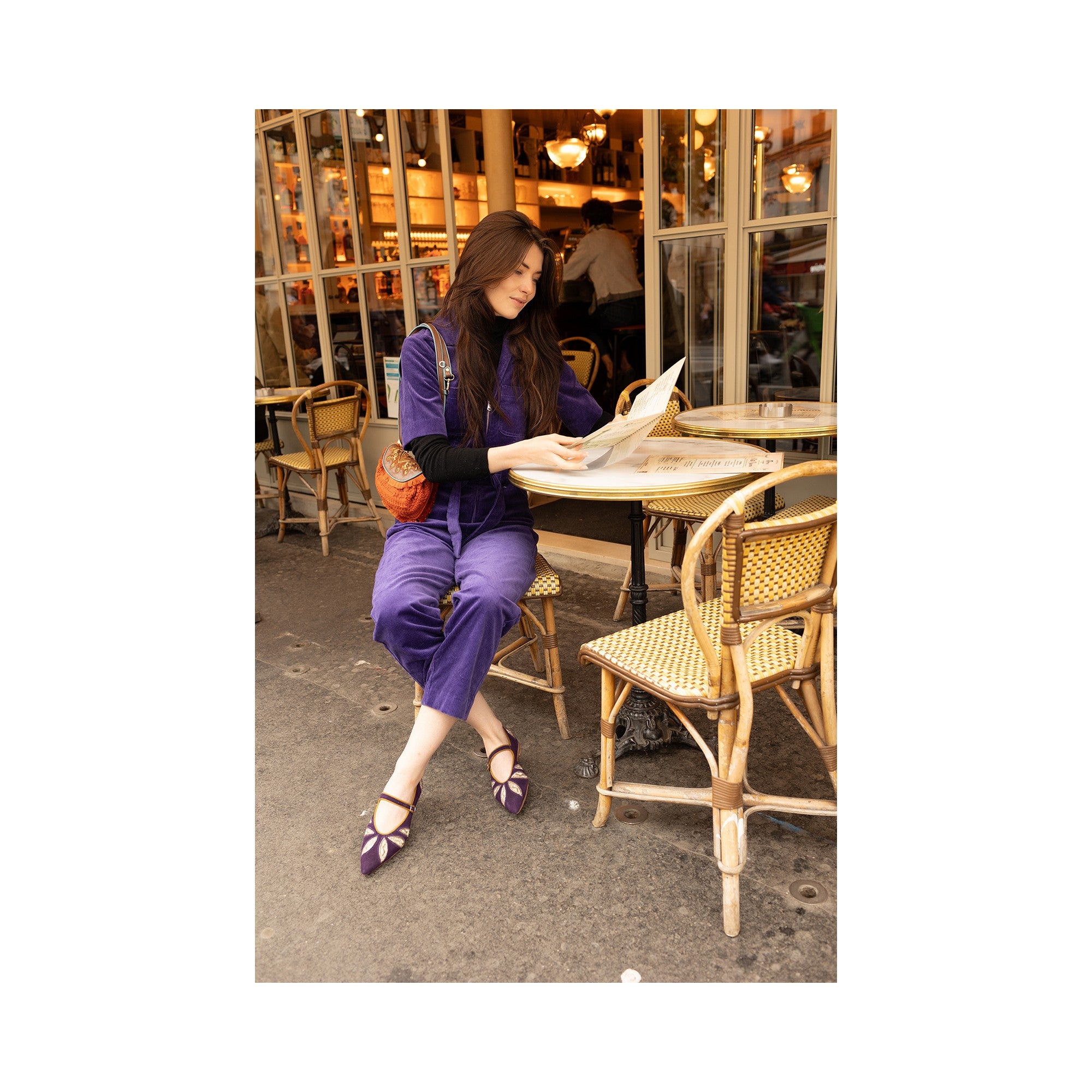 Woman wearing Meher Kakalia LULU POINT purple suede flats with leaf embroidery, seated at a Paris café in a matching outfit.
