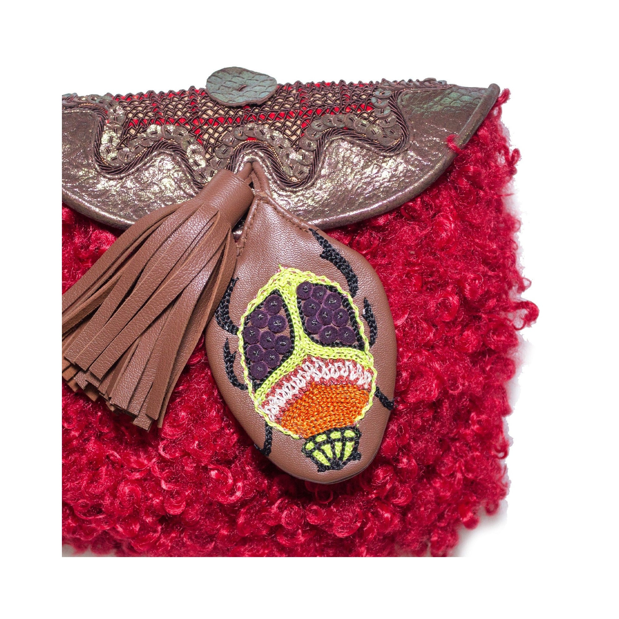 Close-up of mini accordion bag with hand-embroidered leather scarab motif and leather tassel