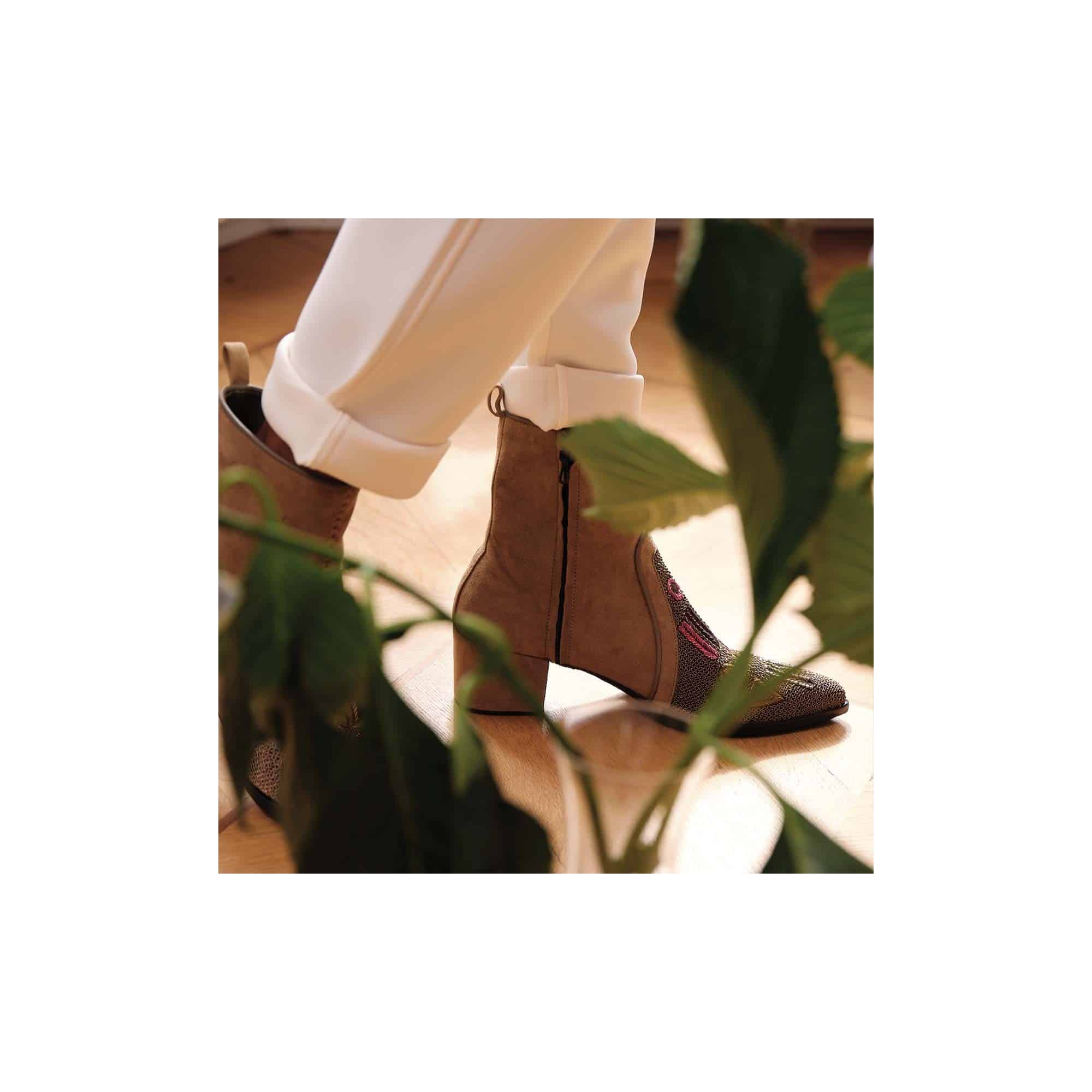 Embroidered suede ankle boots shown in movement with pointed silhouette