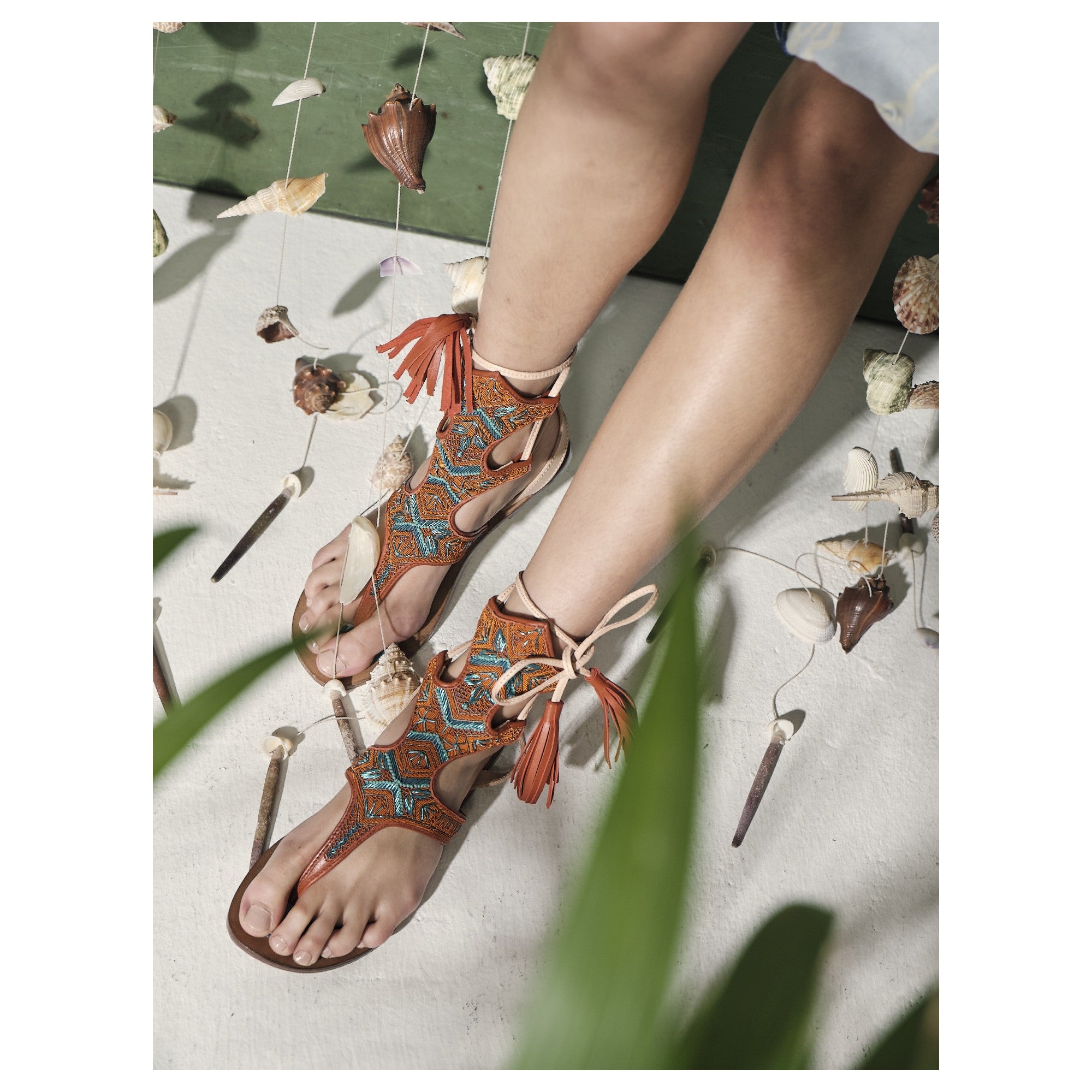 Meher Kakalia hand-embroidered gladiator sandal with turquoise details and leather ties for an elegant summer look.